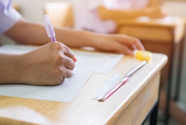 mão escrevendo na mesa da escola