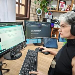 Professora sentada em frente a computador
