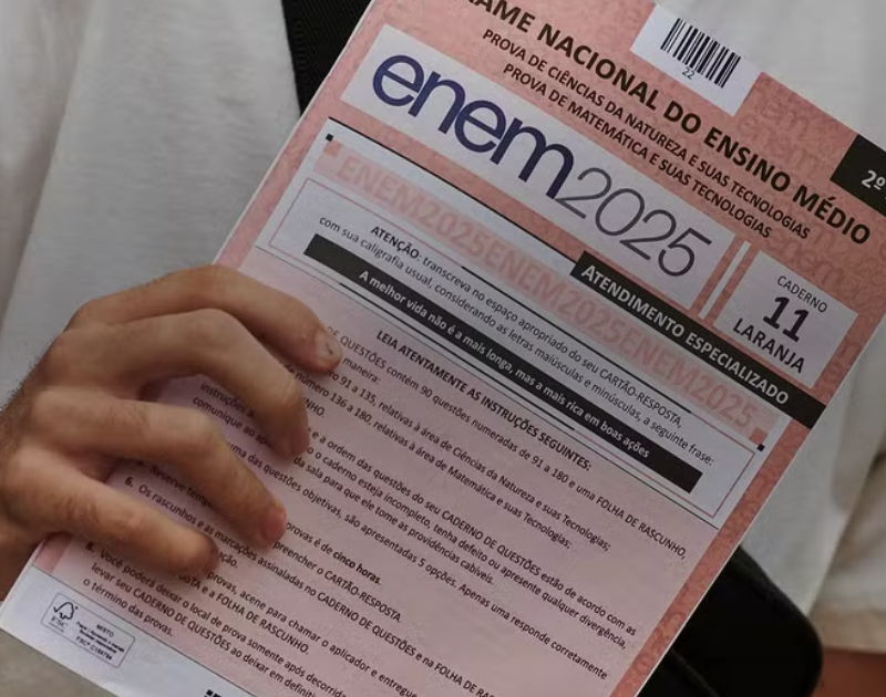 Candidato segurando o caderno de questões do Enem 2025