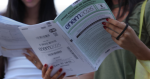 Candidata folheando o caderno de questões do Enem 2025 antes da prova