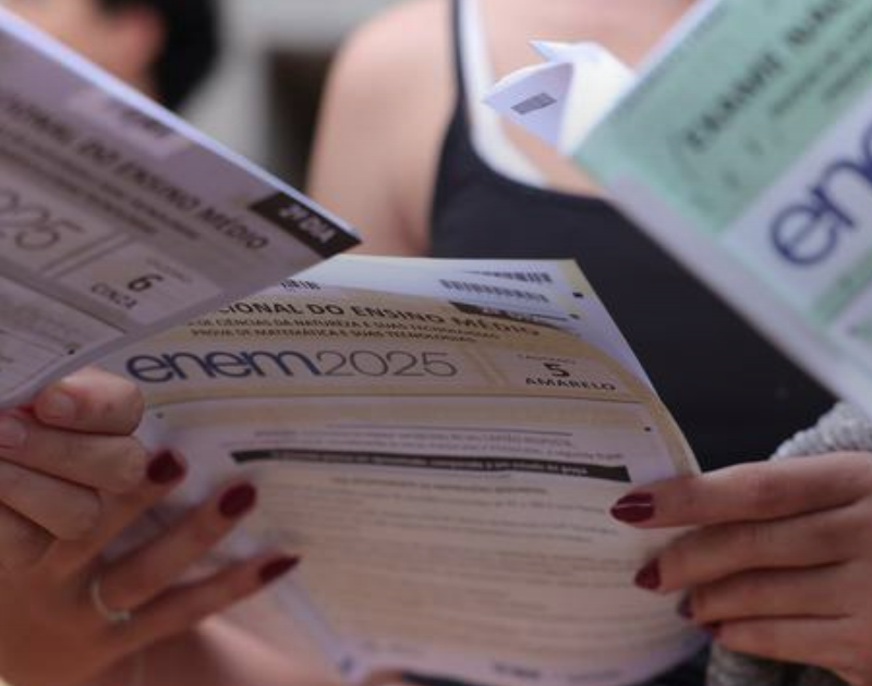 Candidatos segurando os cadernos de prova do Enem 2025