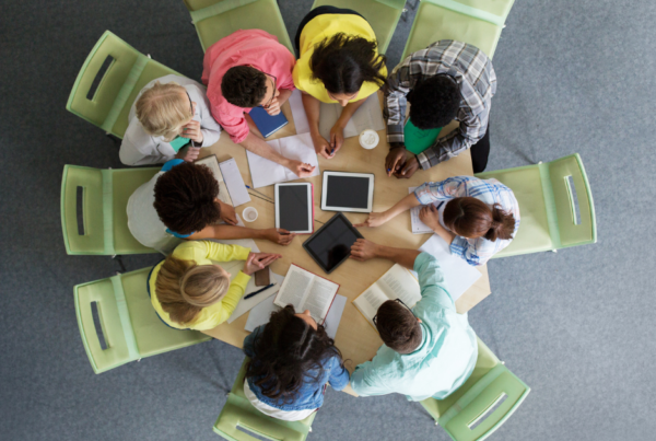 Vista de cima de estudantes em roda estudando com livros e tablets
